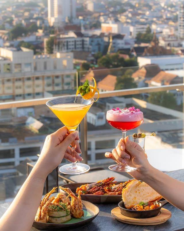 Rooftop cocktails and appetizers with city skyline view.