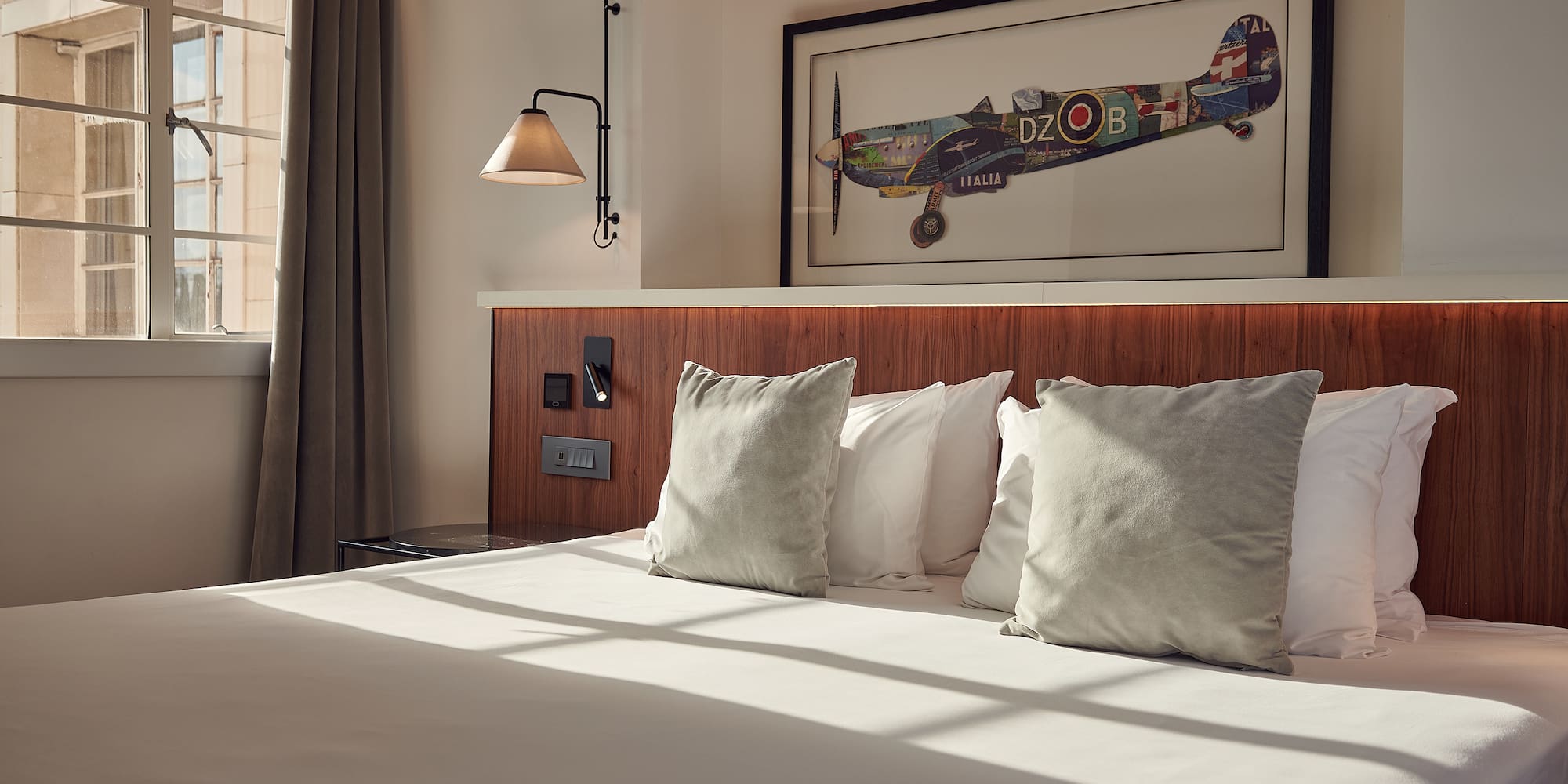 a bed with pillows and a picture on the wall