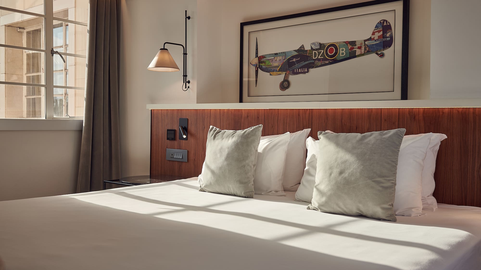 a bed with pillows and a picture on the wall