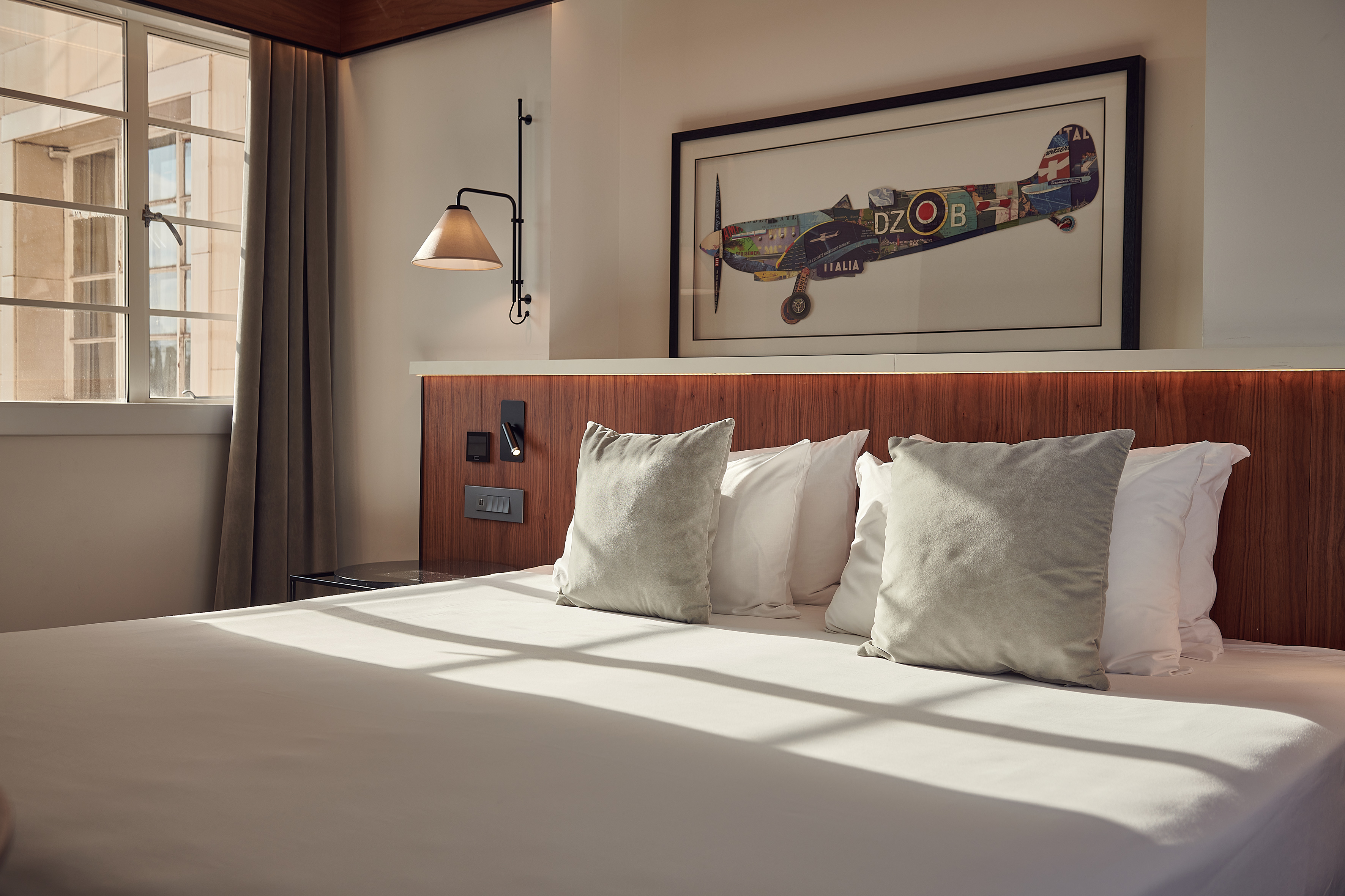 a bed with pillows and a picture on the wall