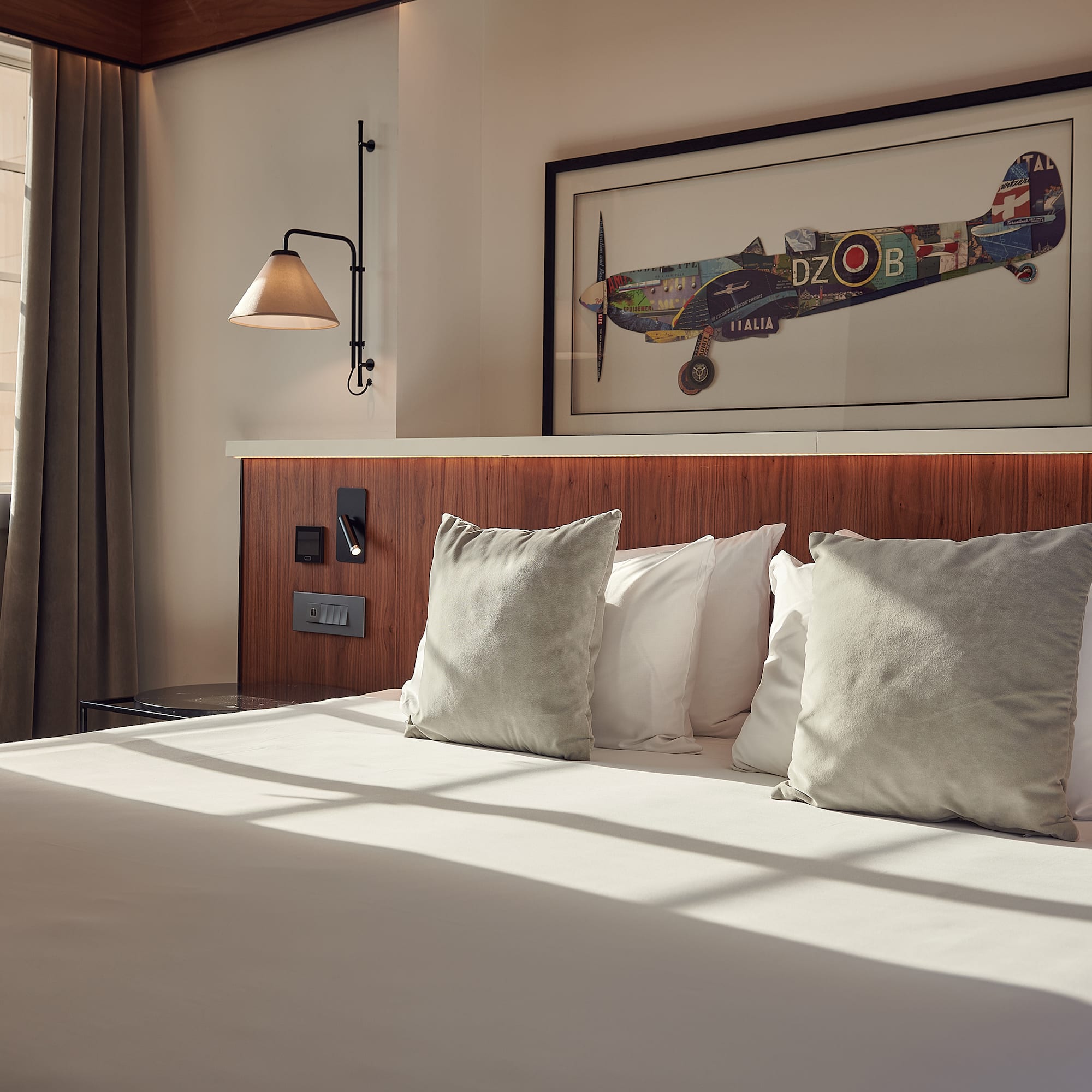 a bed with pillows and a picture on the wall