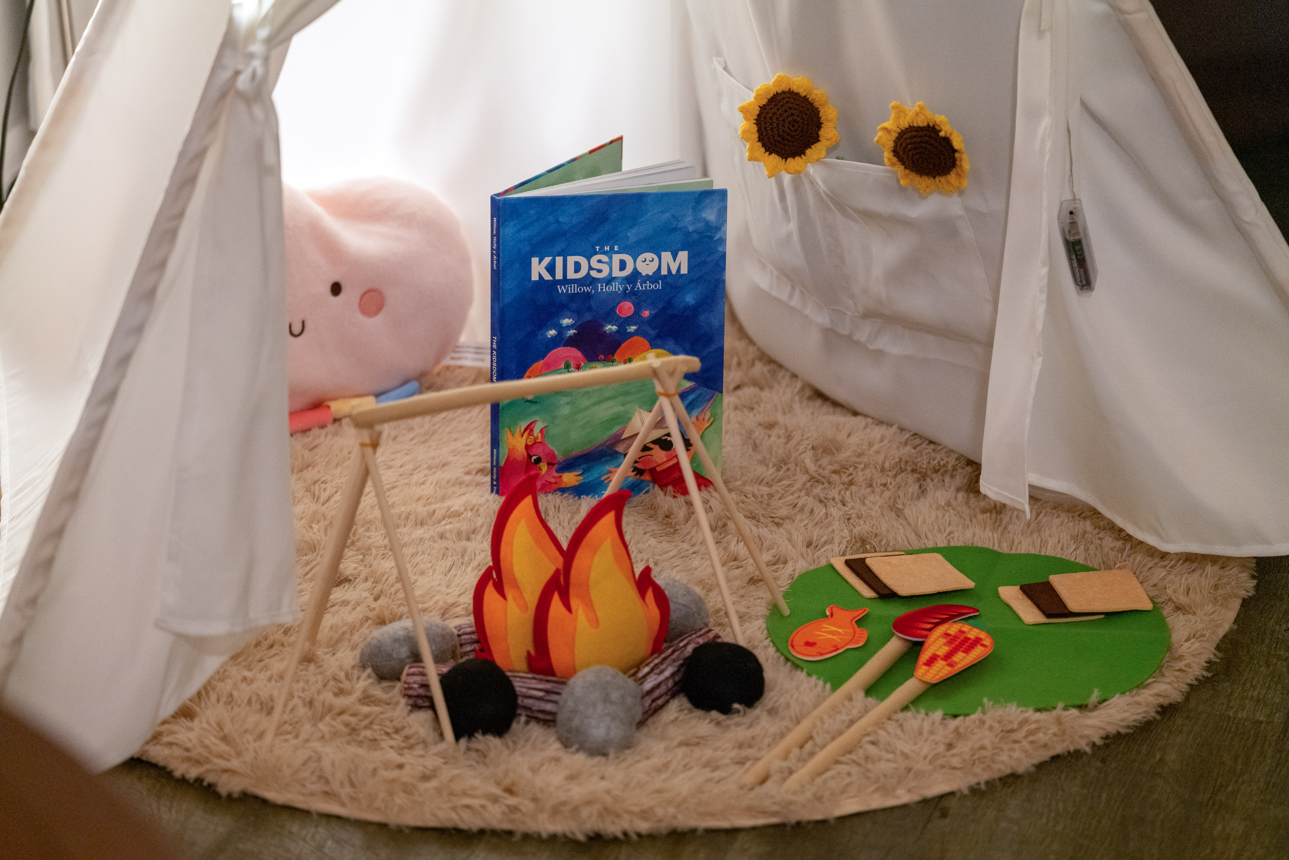 Indoor camping play tent with pretend campfire, s'mores, and kids' book.