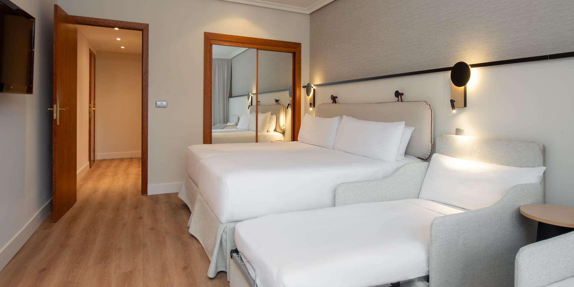 a room with two beds and a mirror