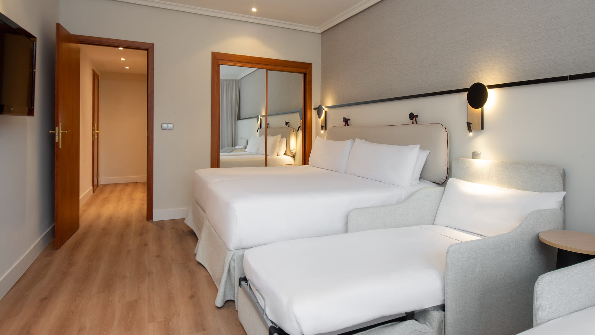 a room with two beds and a mirror