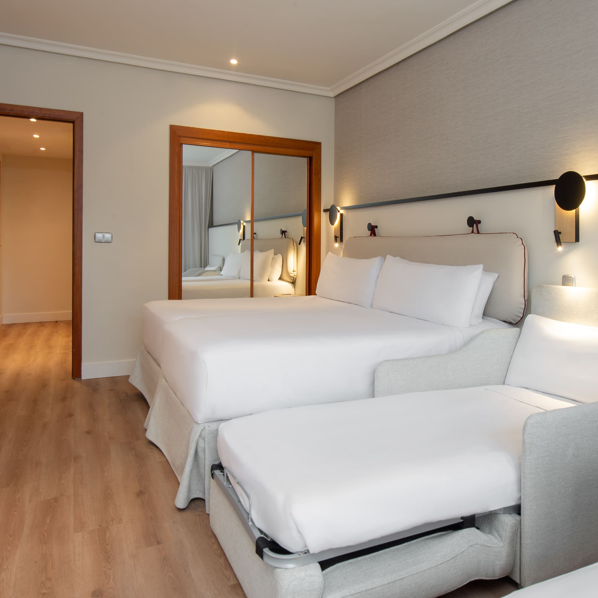 a room with two beds and a mirror