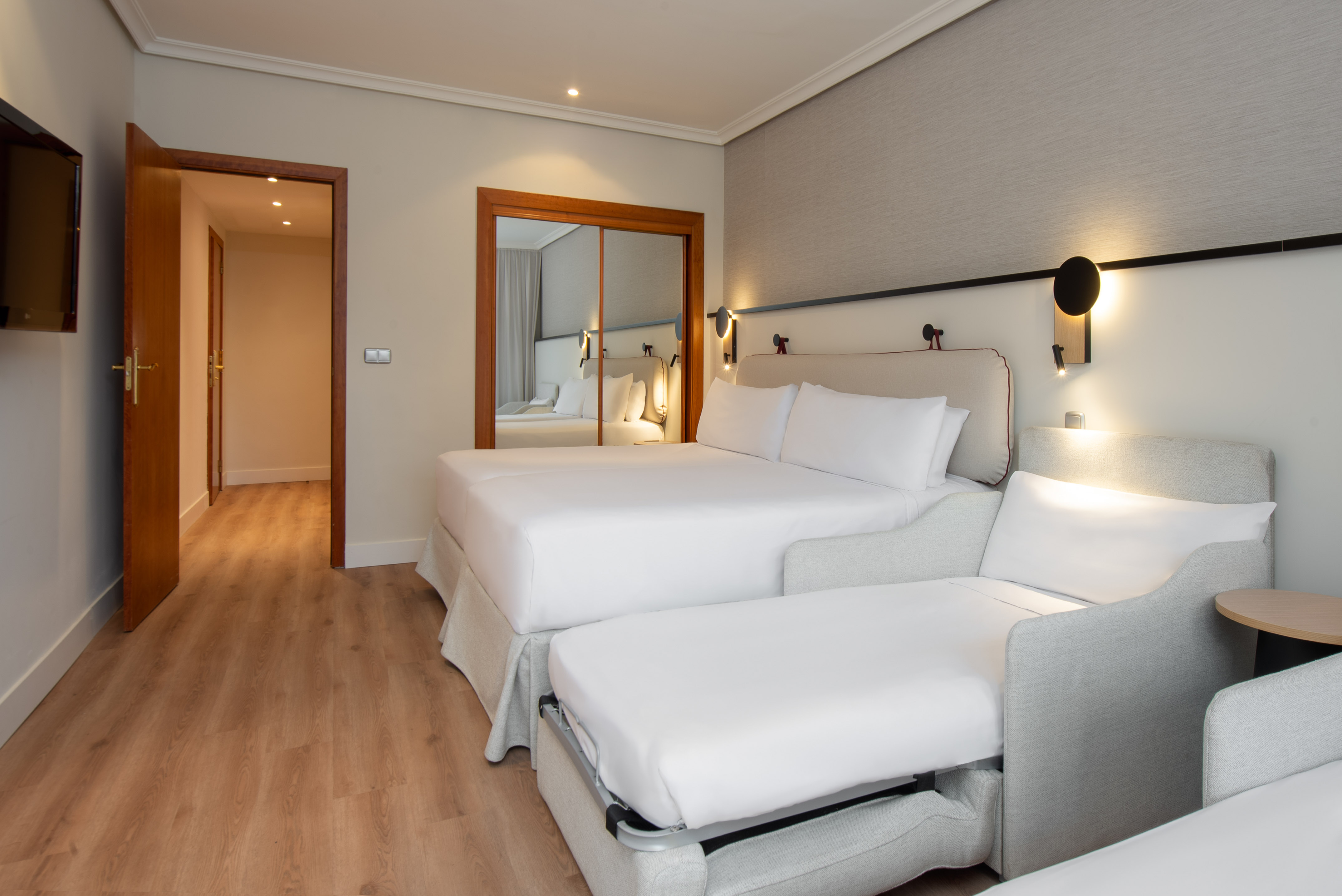 a room with two beds and a mirror