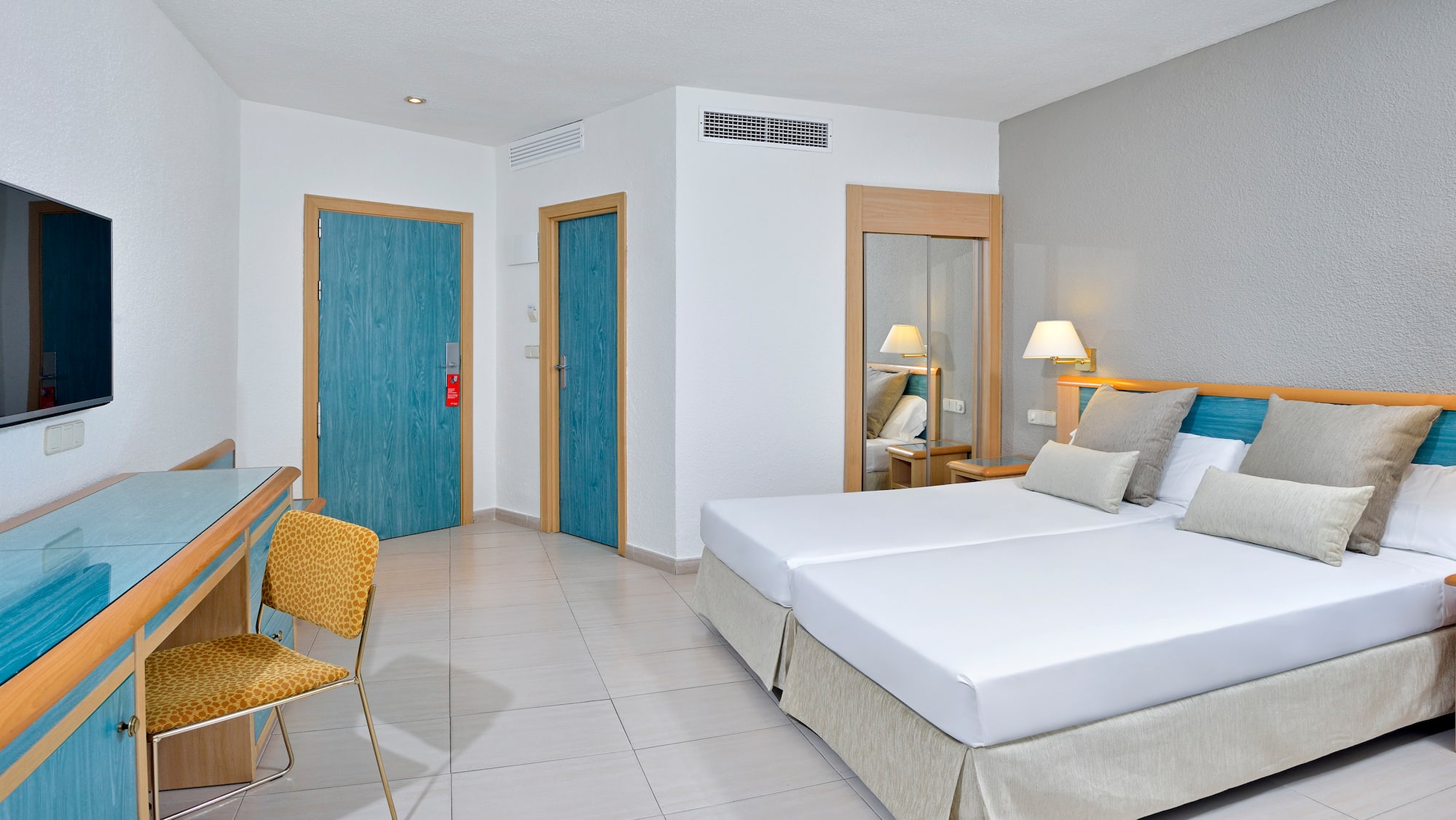 a room with two beds and a chair