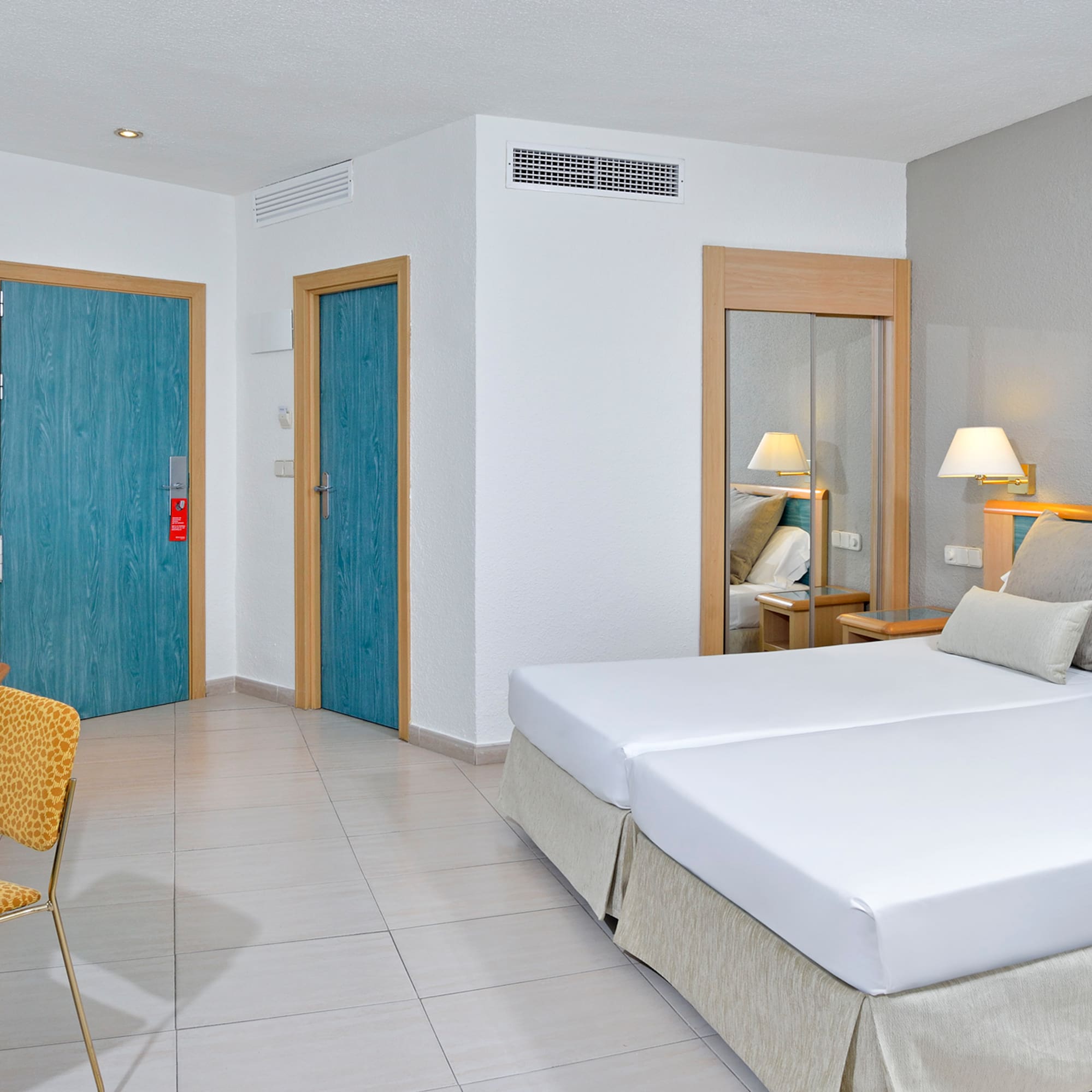 a room with two beds and a chair