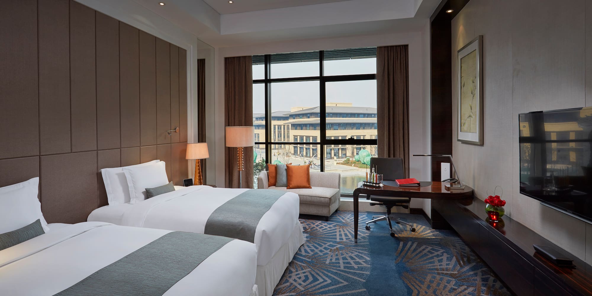 a room with two beds and a desk