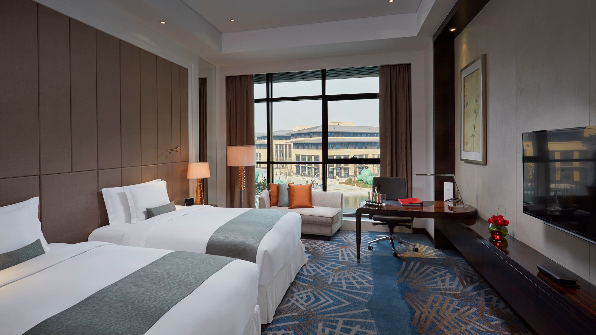 a room with two beds and a desk