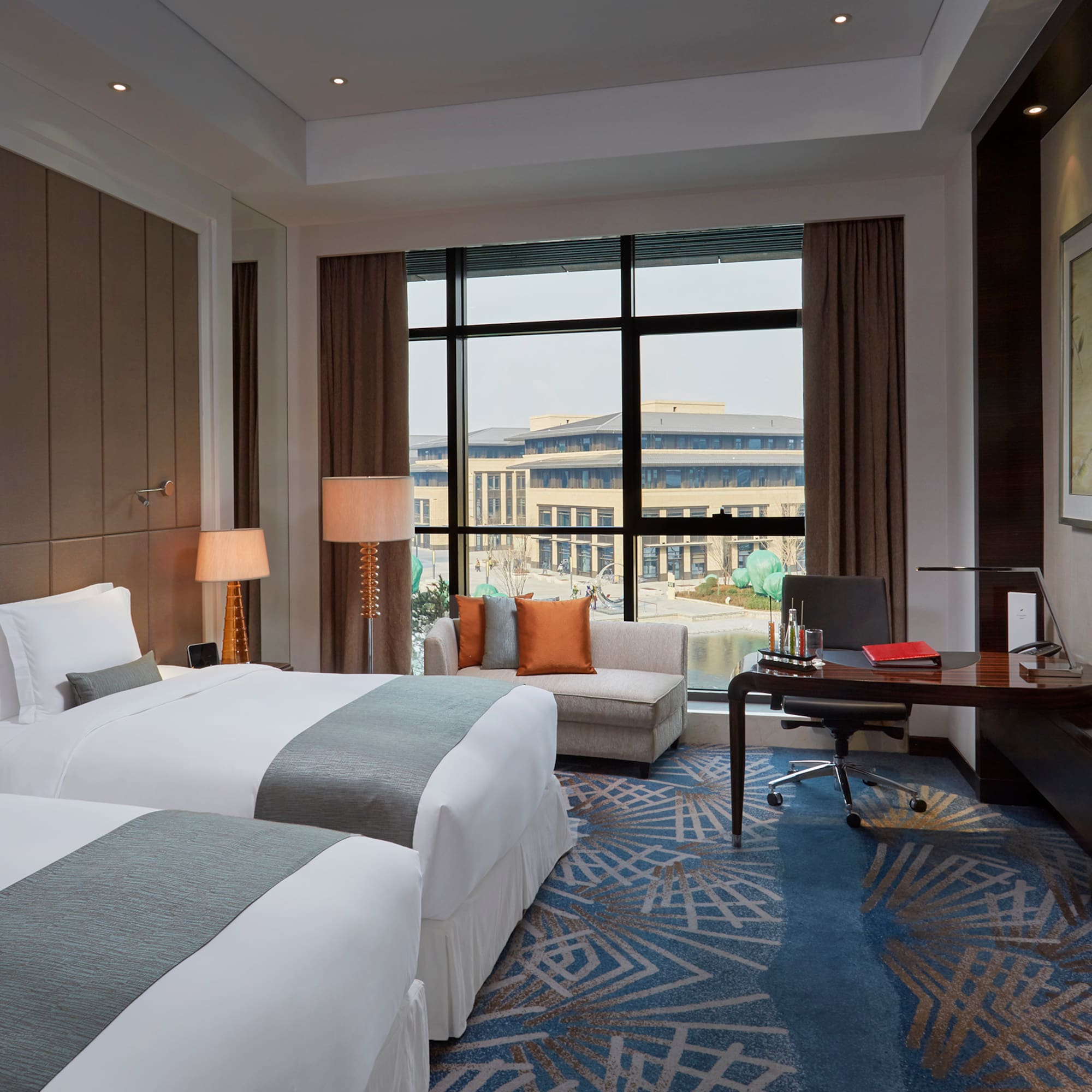 a room with two beds and a desk