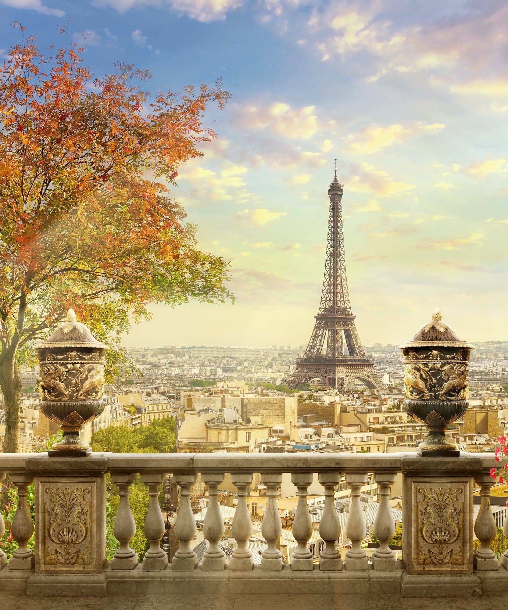 Eiffel Tower over autumn Paris from a balustrade with decorative urns.