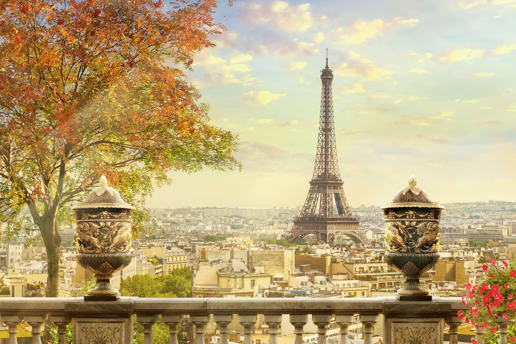 Eiffel Tower over autumn Paris from a balustrade with decorative urns.