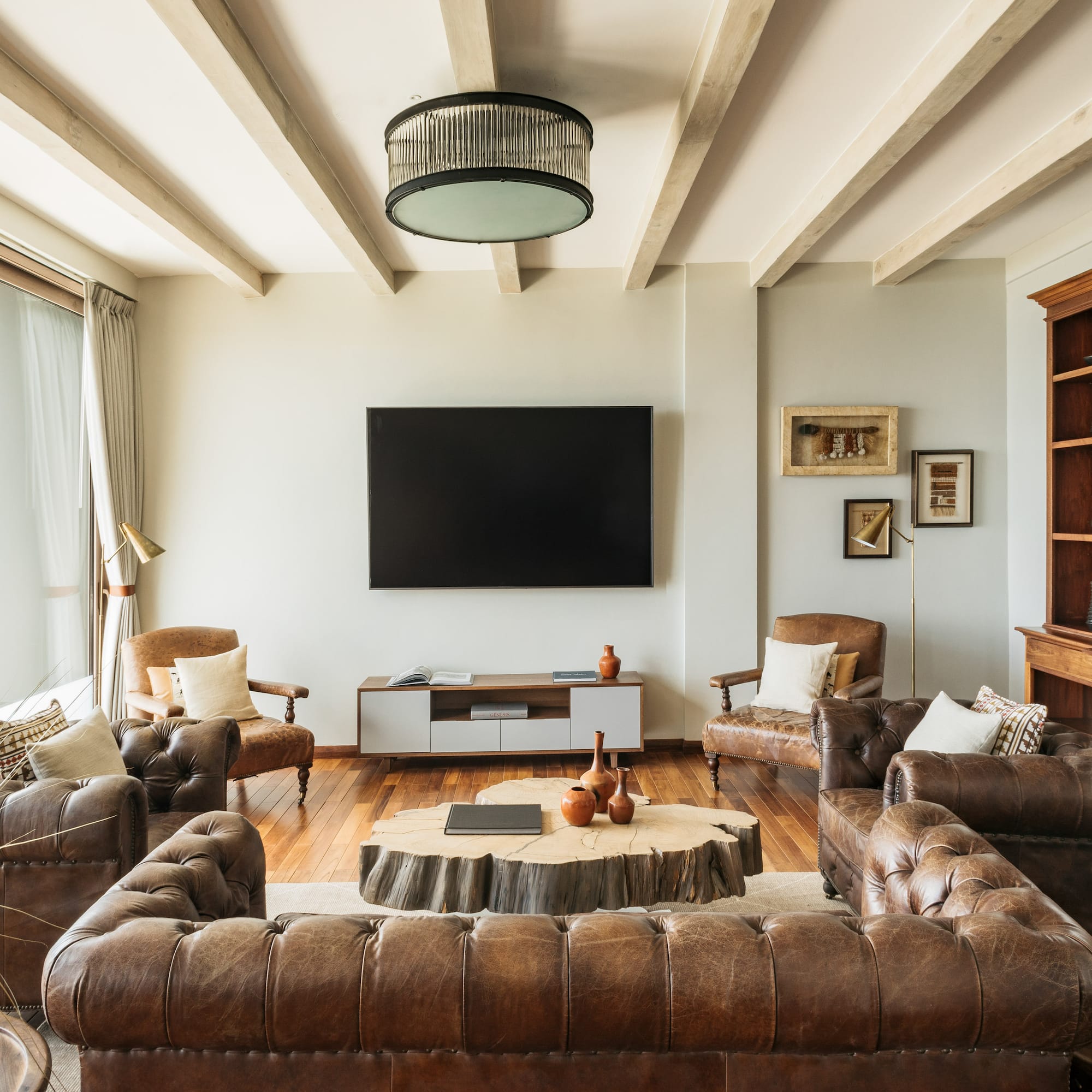 a living room with leather couches and a tv