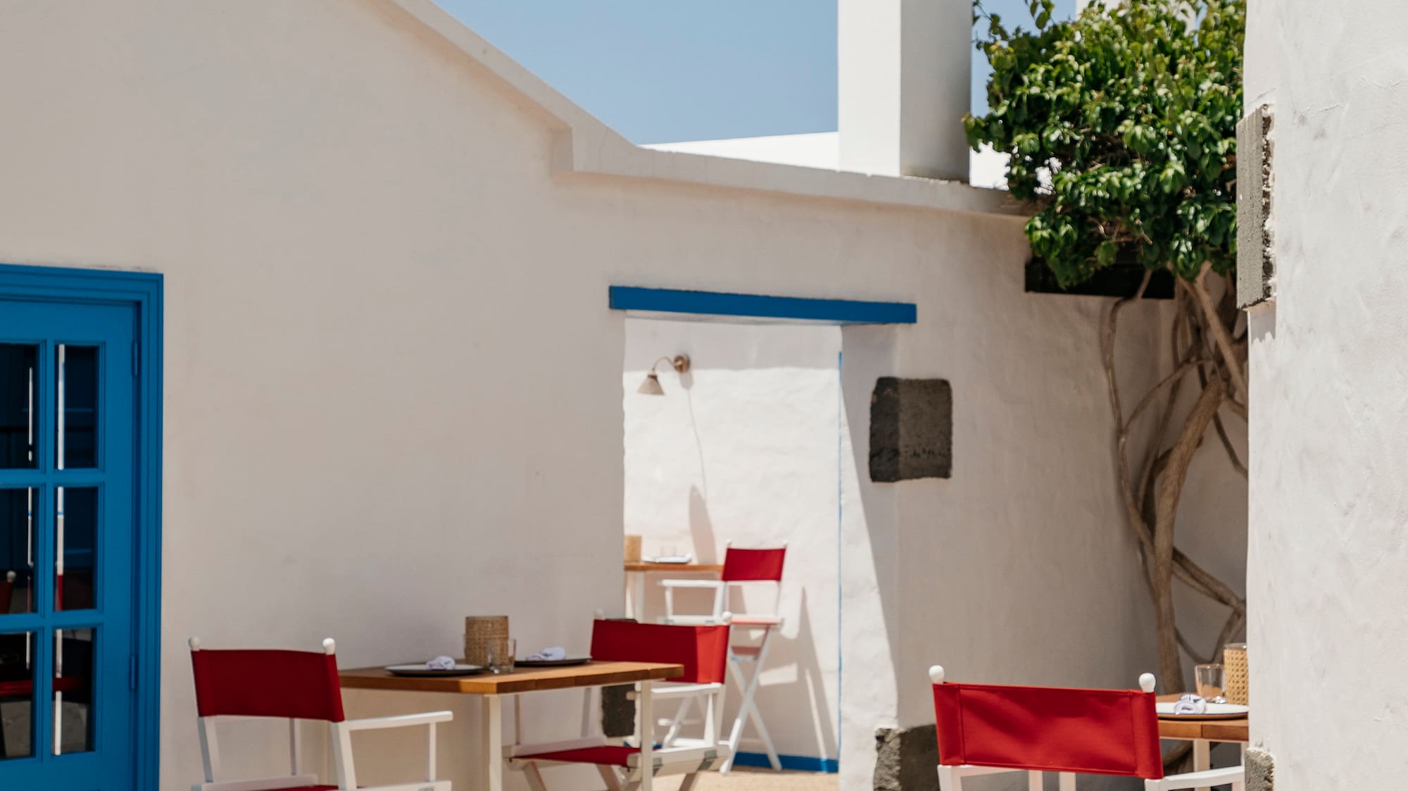 a white building with red chairs and a bell