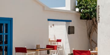 a white building with red chairs and a bell