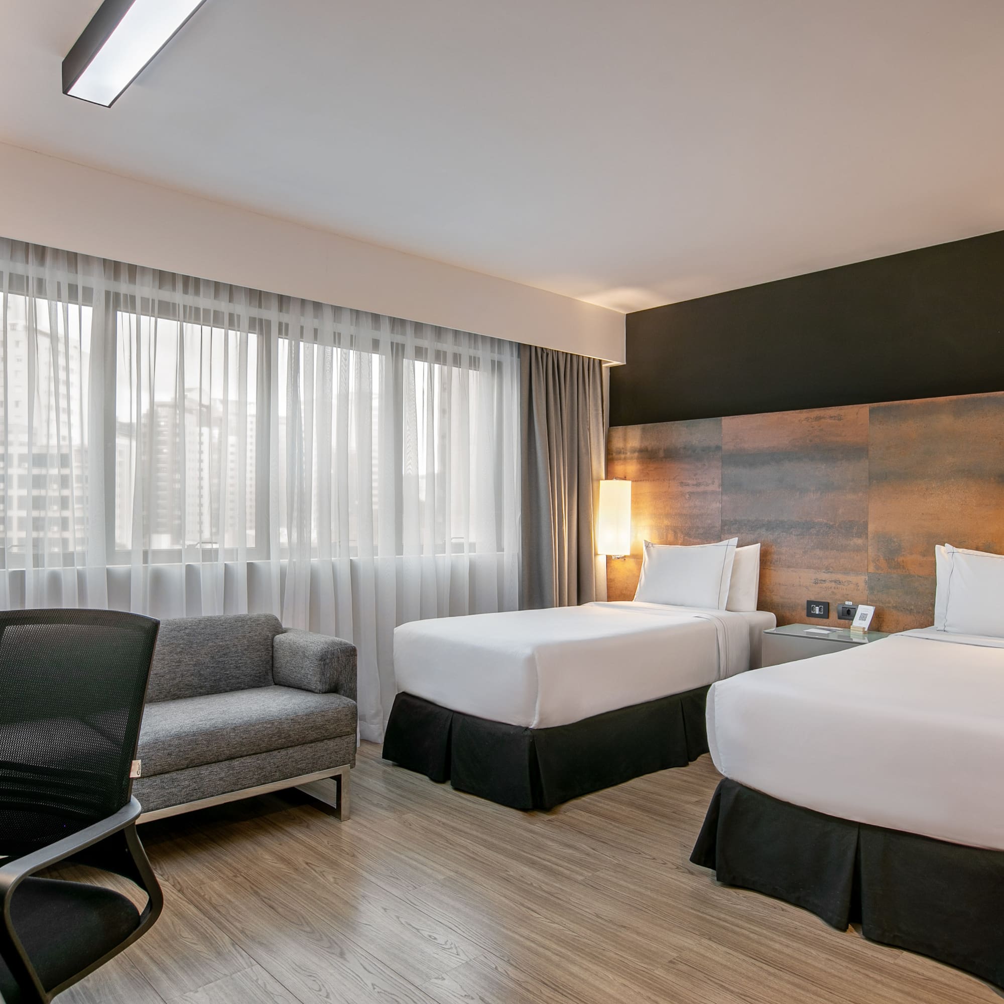 Quarto de hotel moderno com duas camas de solteiro e janela grande. - Deluxe Room Twin - Meliá Ibirapuera, São Paulo