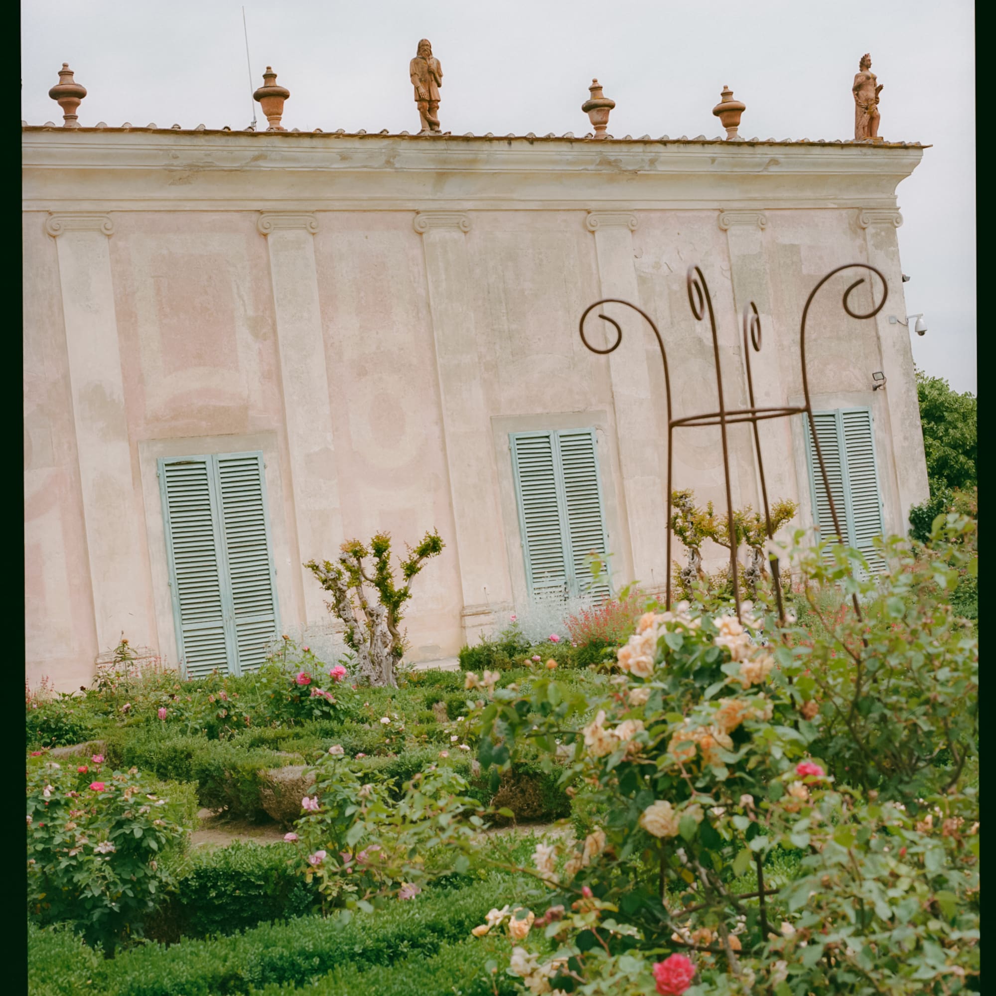 a building with a garden and statues on the roof