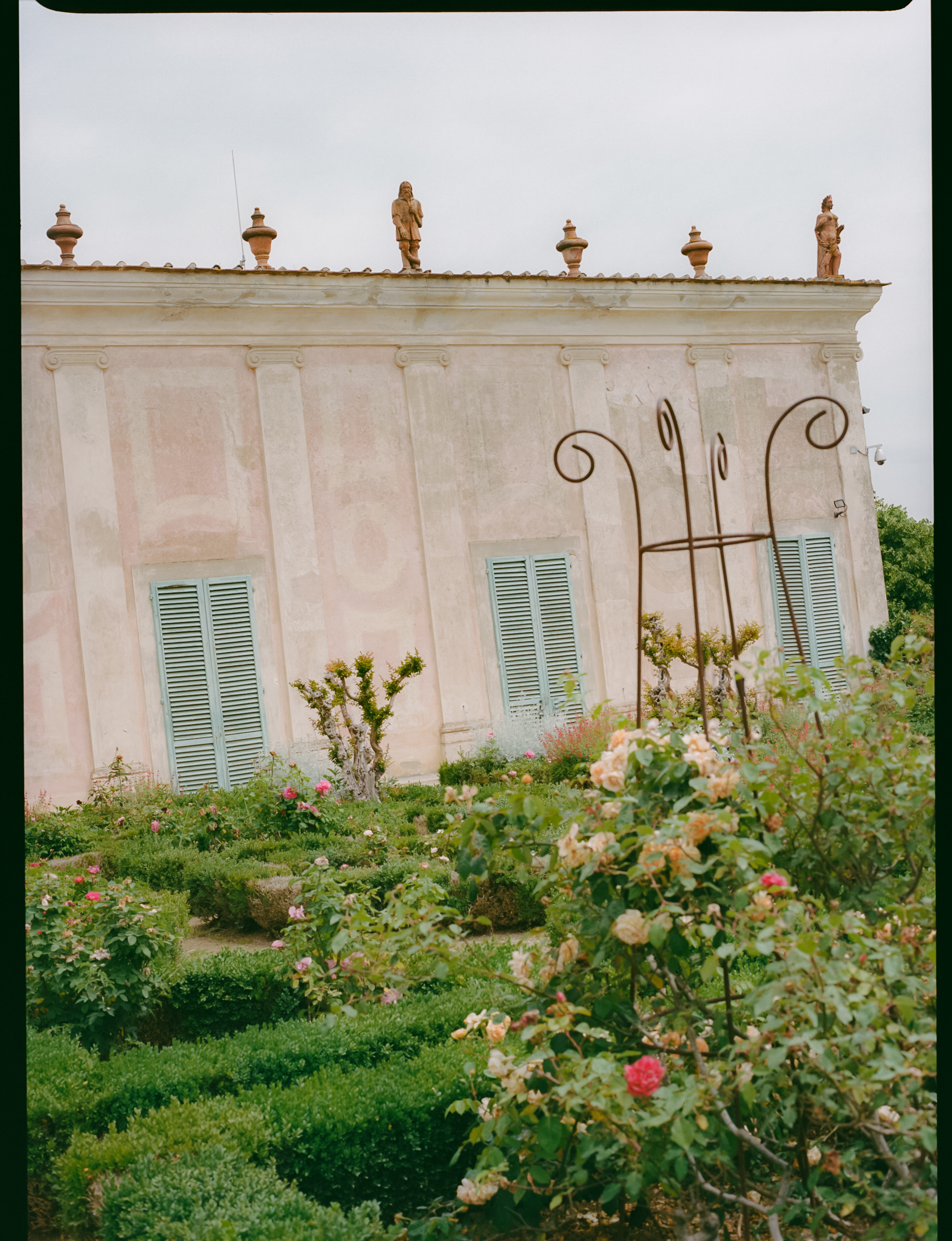 a building with a garden and statues on the roof