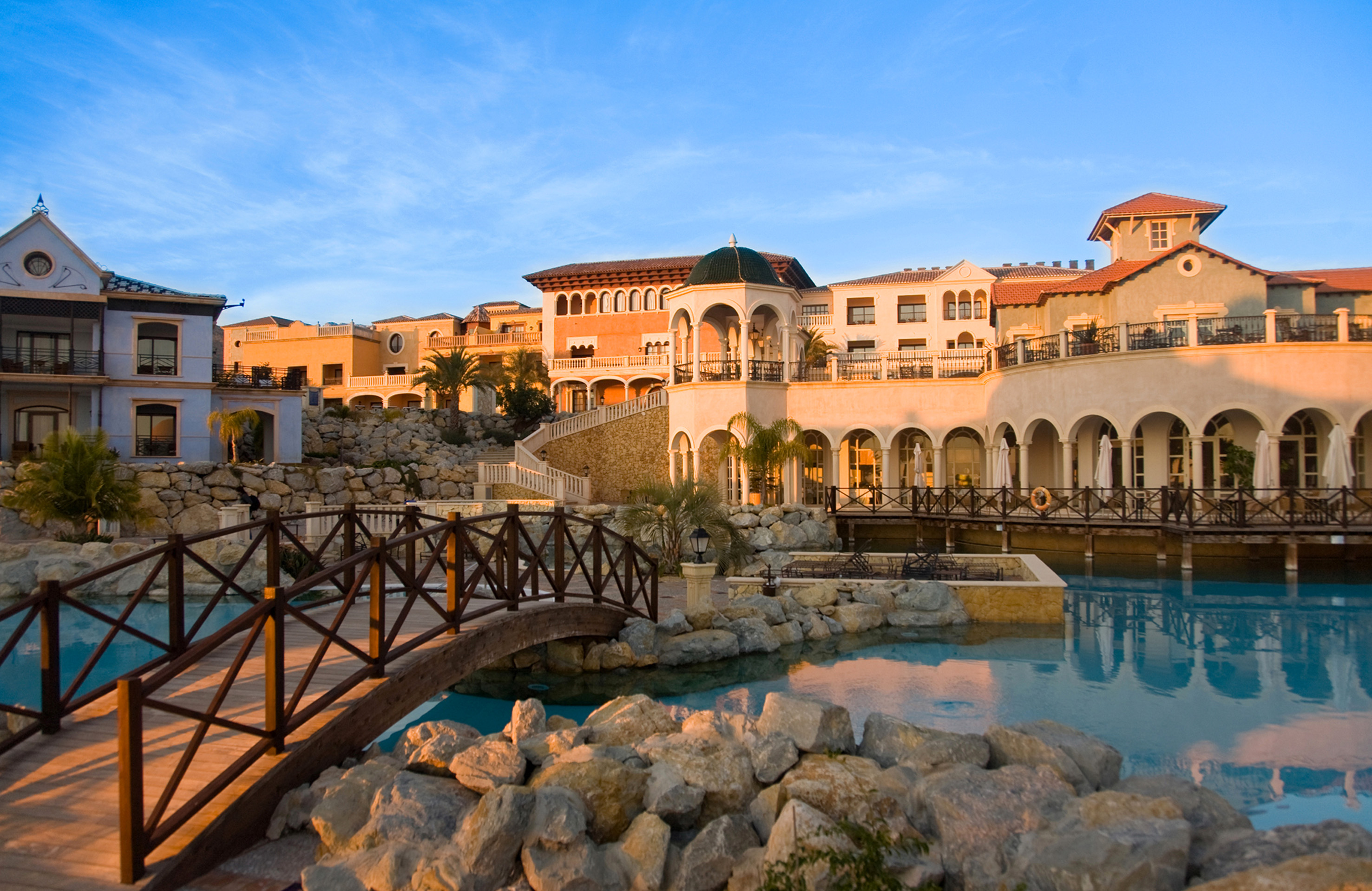 a bridge over a pool with a building in the background