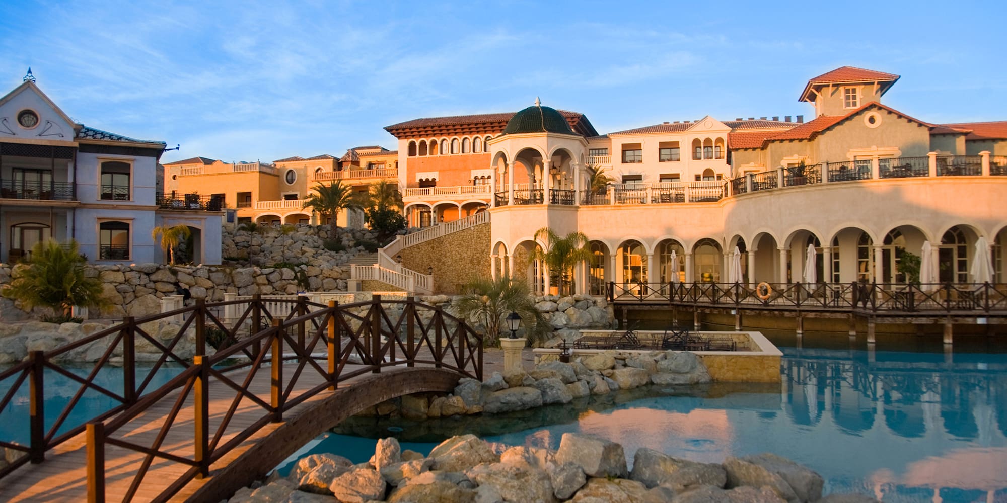 a bridge over a pool with a building in the background