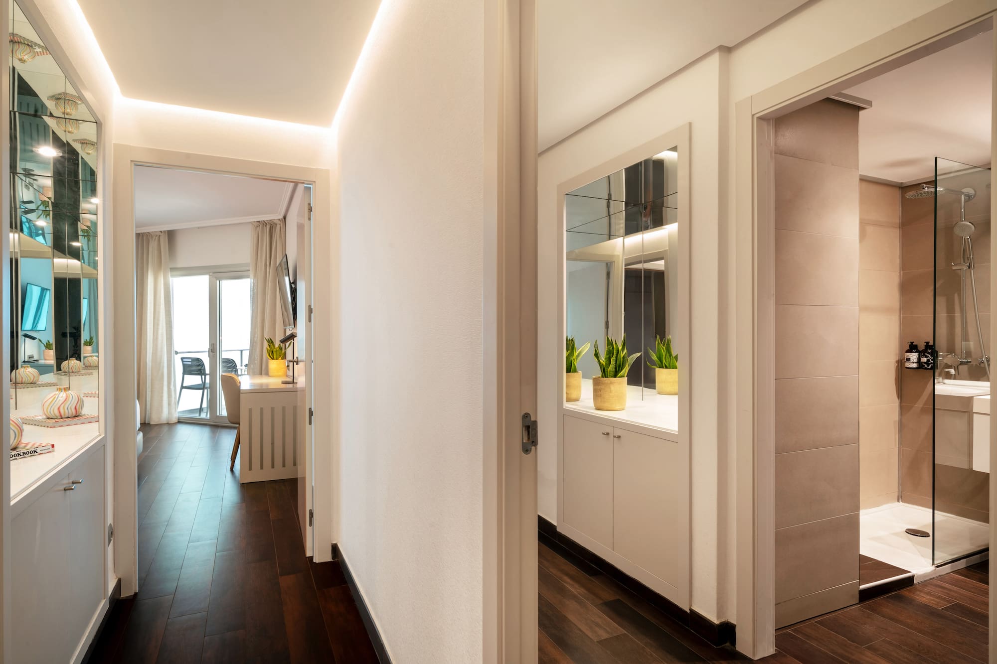 a hallway with a door open and a mirror