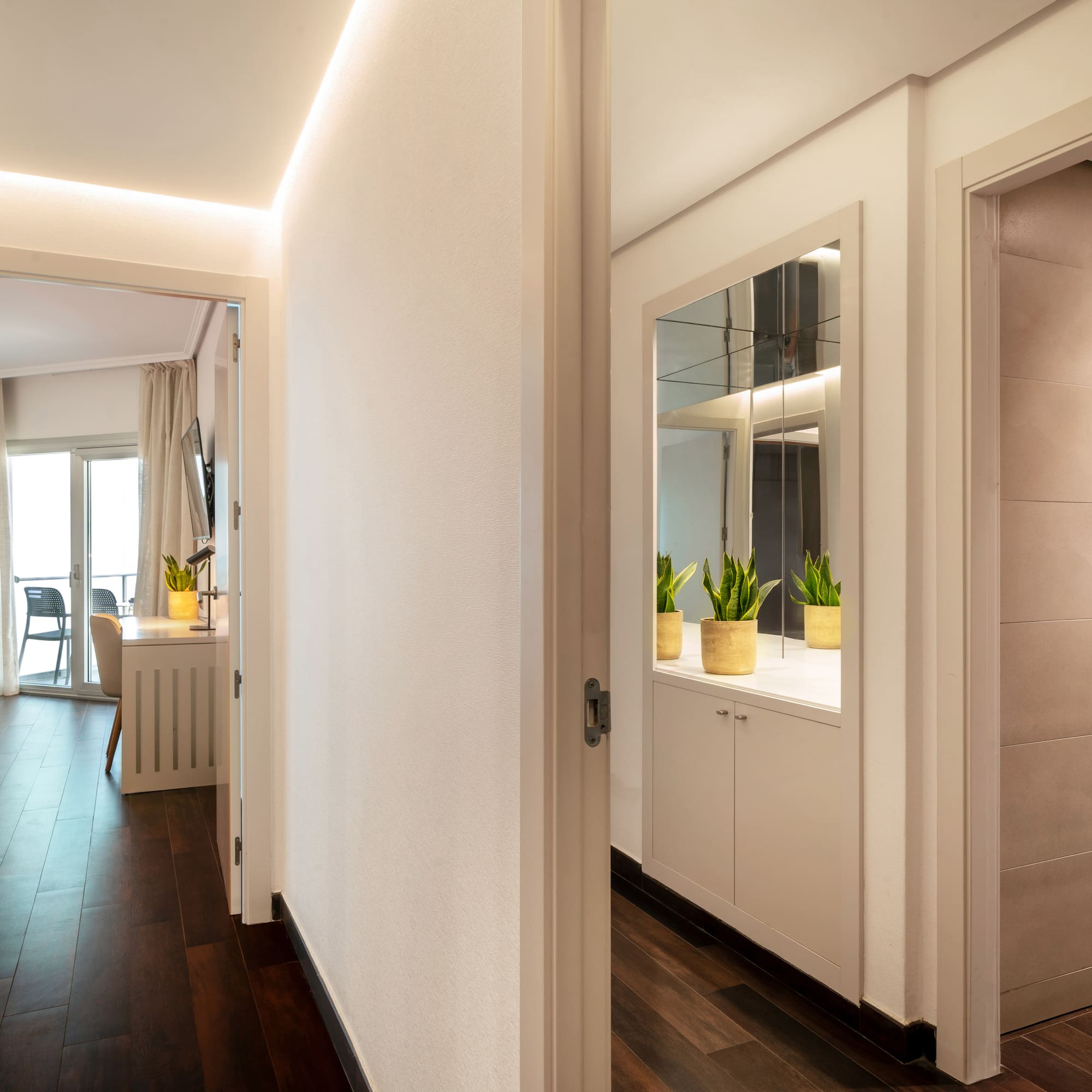 a hallway with a door open and a mirror