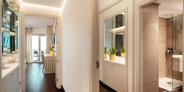 a hallway with a door open and a mirror