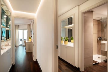 a hallway with a door open and a mirror