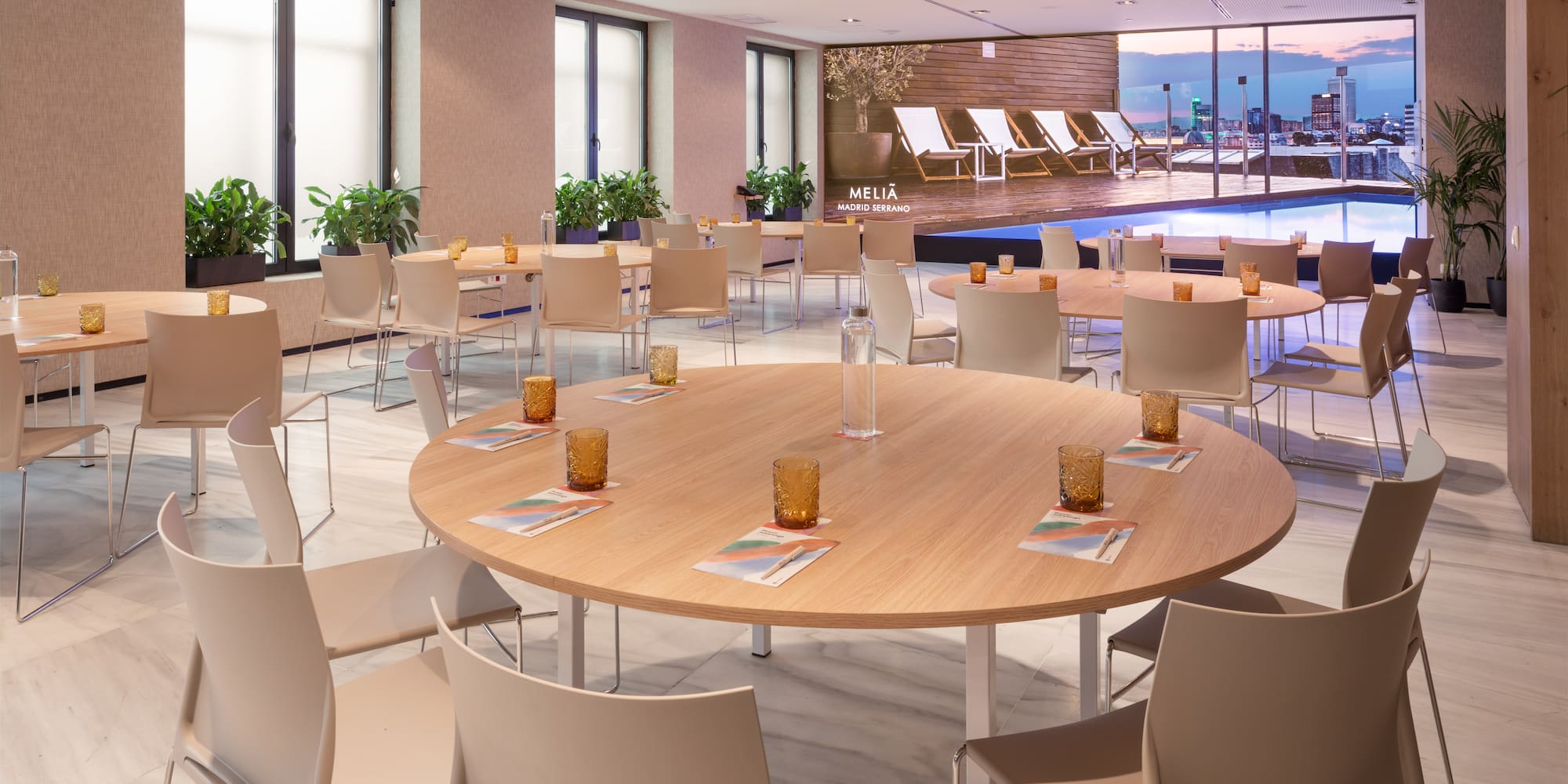 Meliá Madrid Serrano conference room with round tables, city view, and rooftop pool.