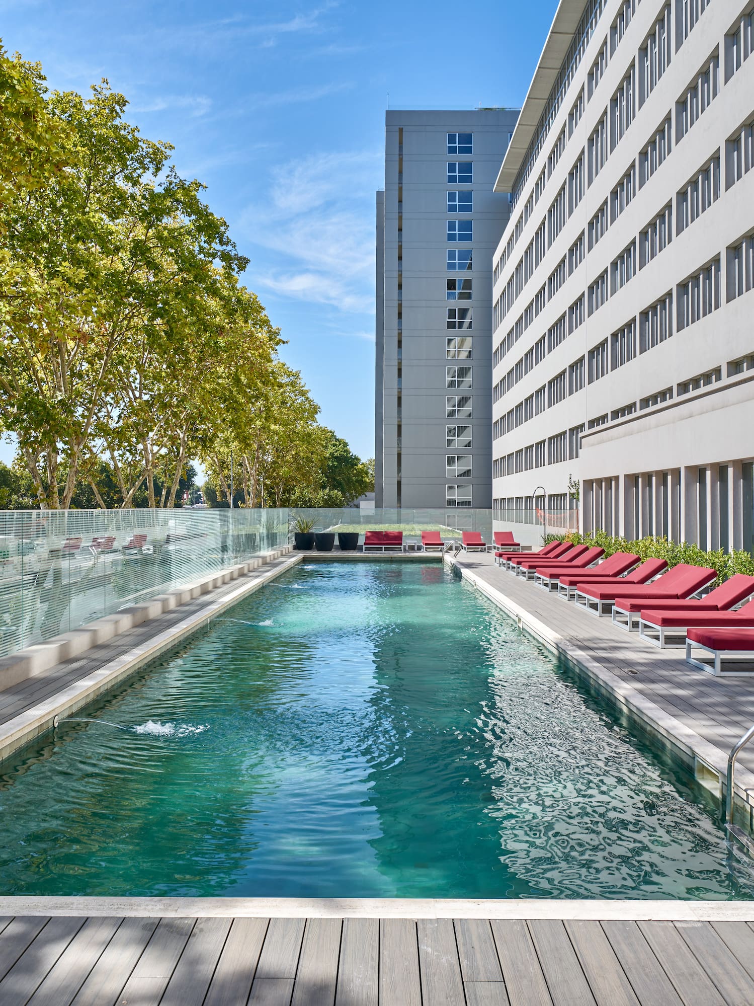a pool with lounge chairs and a building