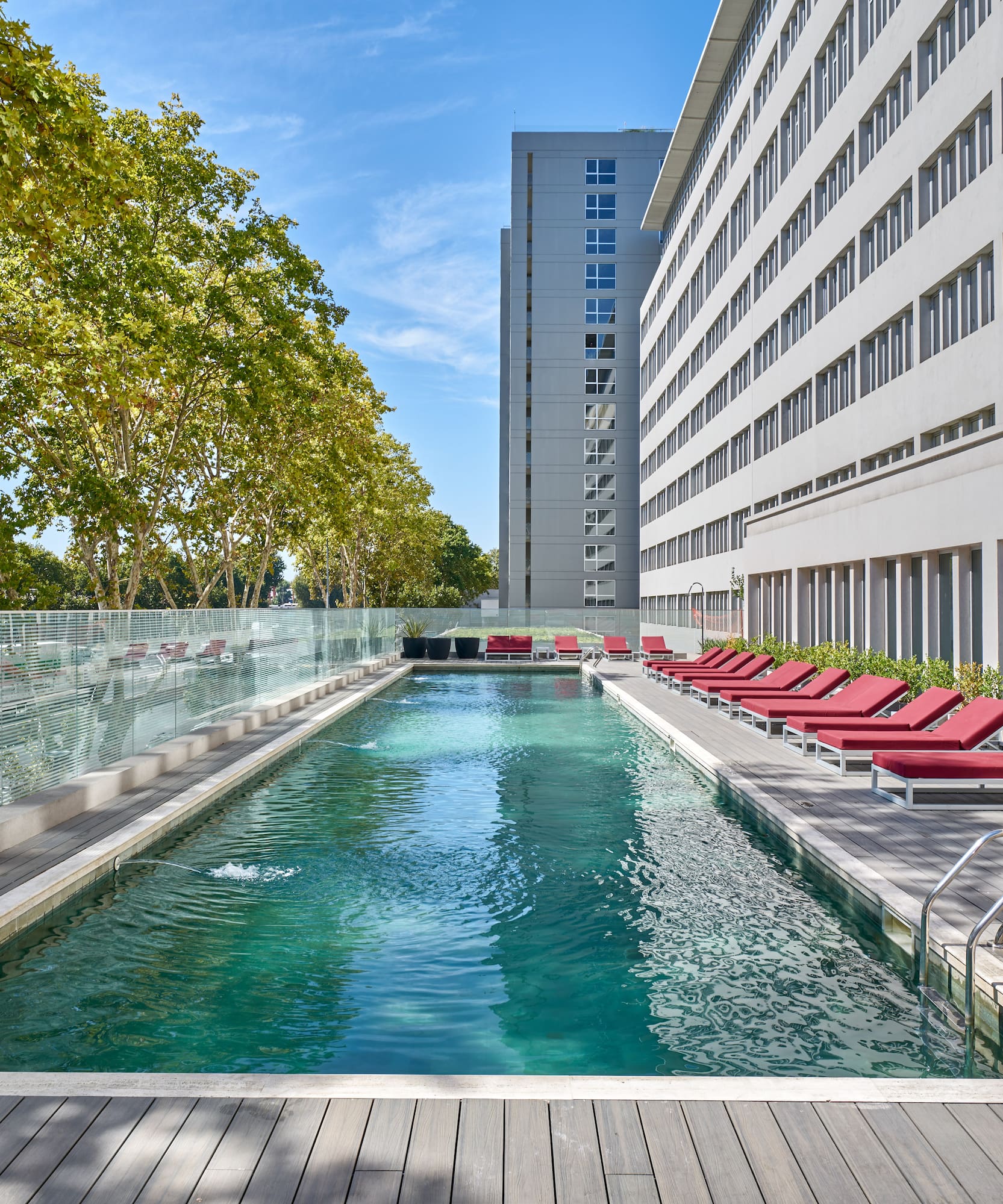 a pool with lounge chairs and a building