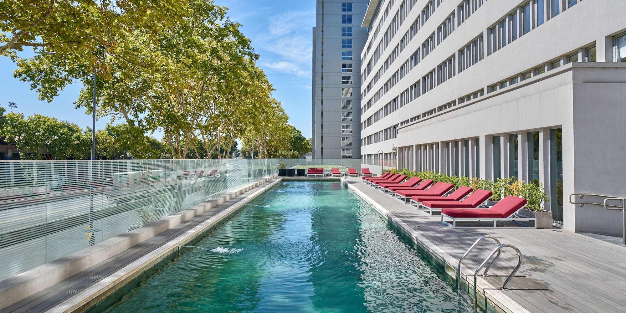 a pool with lounge chairs and a building