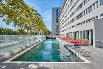 a pool with lounge chairs and a building