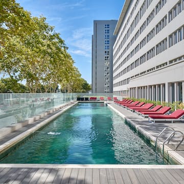 a pool with lounge chairs and a building