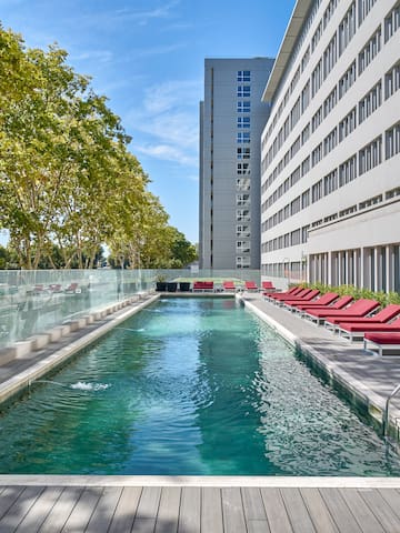 a pool with lounge chairs and a building