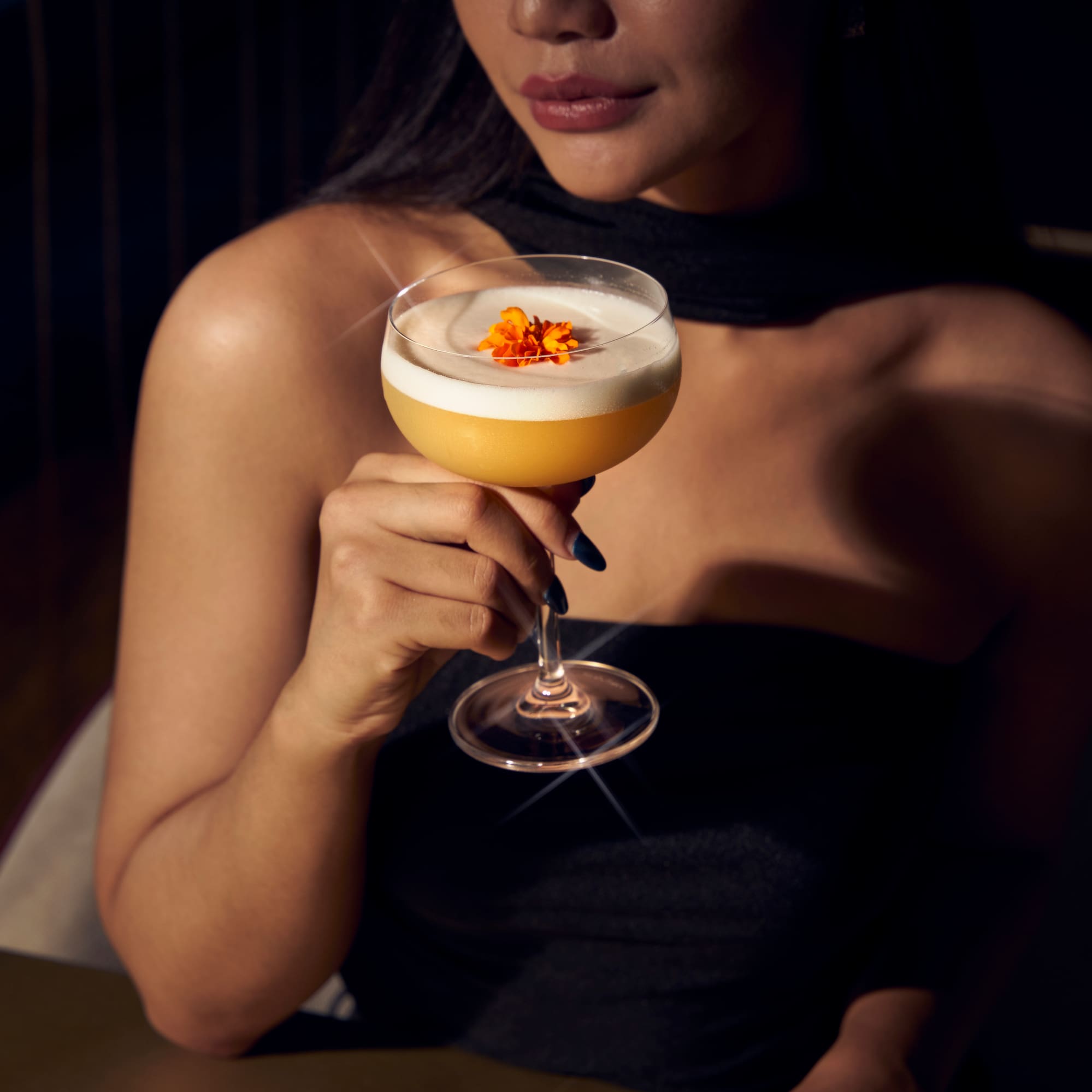 a woman drinking a drink in front of a city