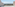 Balcony with glass railing overlooking bay, palm trees, and distant city skyline.