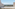 Balcony with glass railing overlooking bay, palm trees, and distant city skyline.