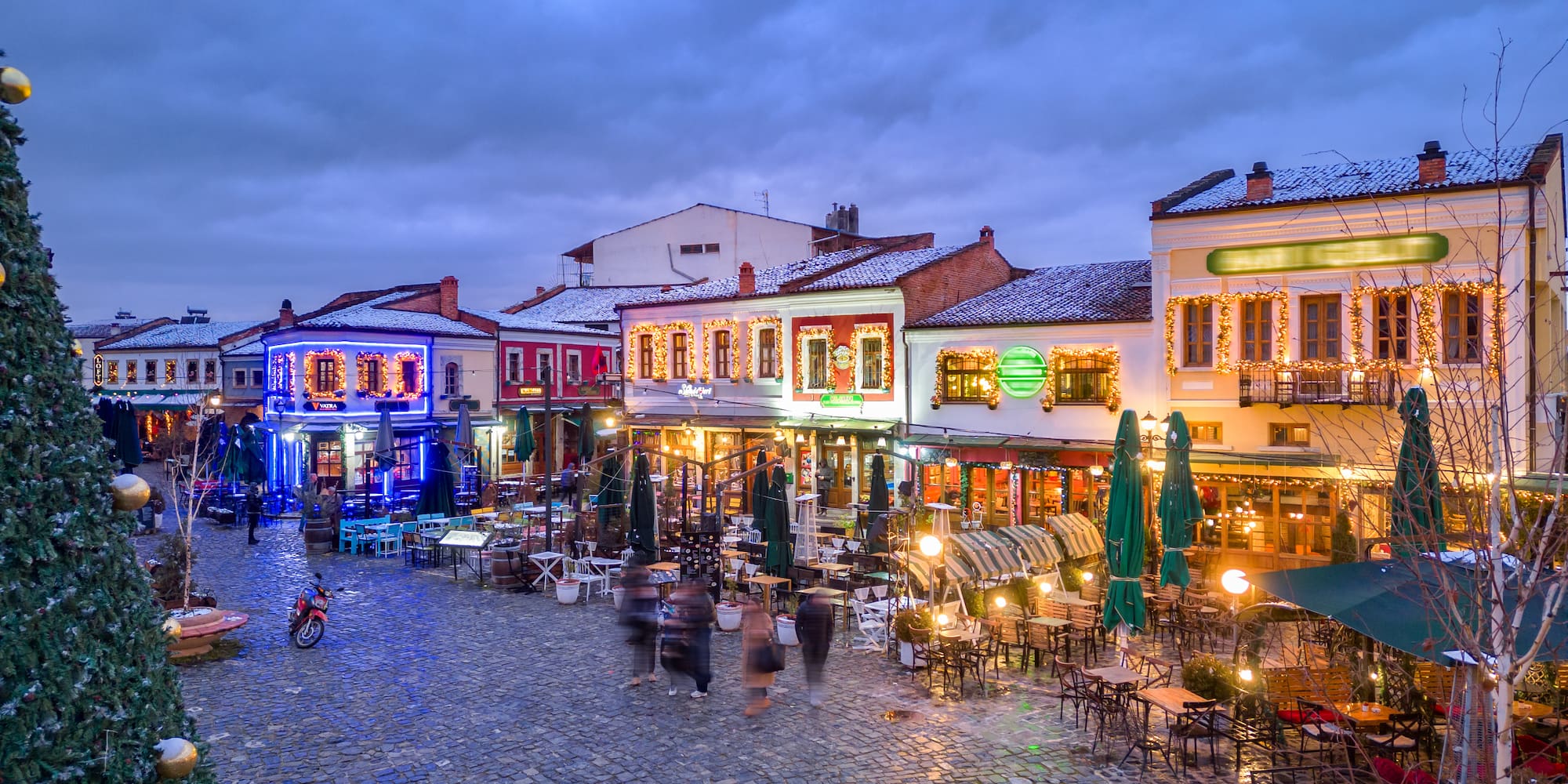 a street with tables and chairs and people in the street