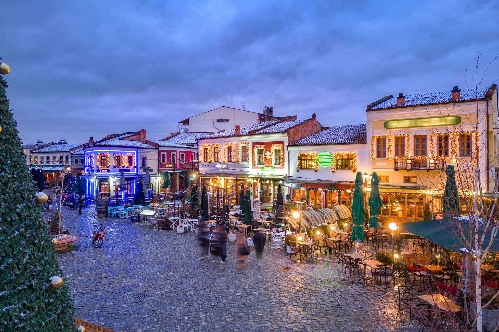 a street with tables and chairs and people in the street