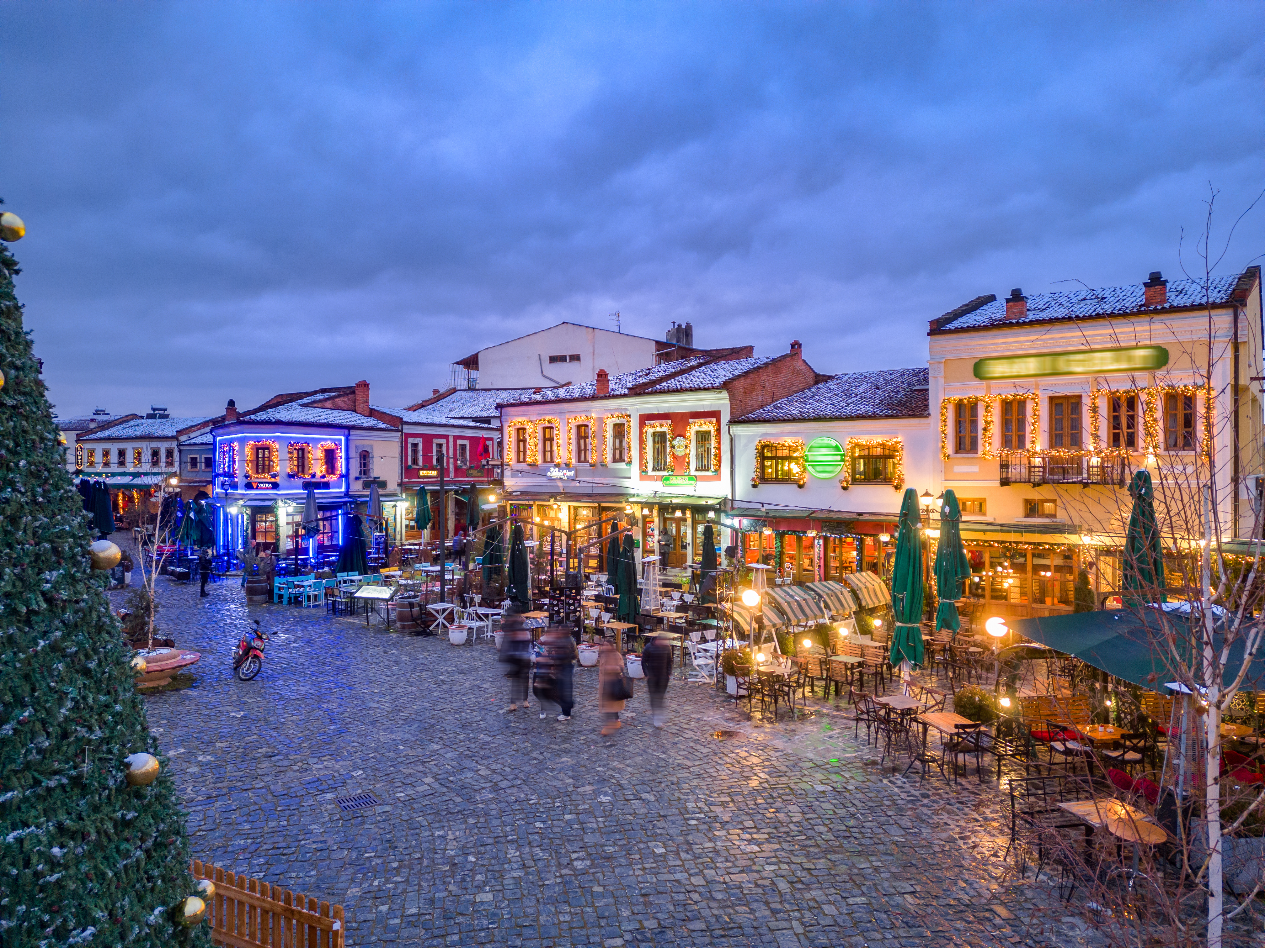 a street with tables and chairs and people in the street