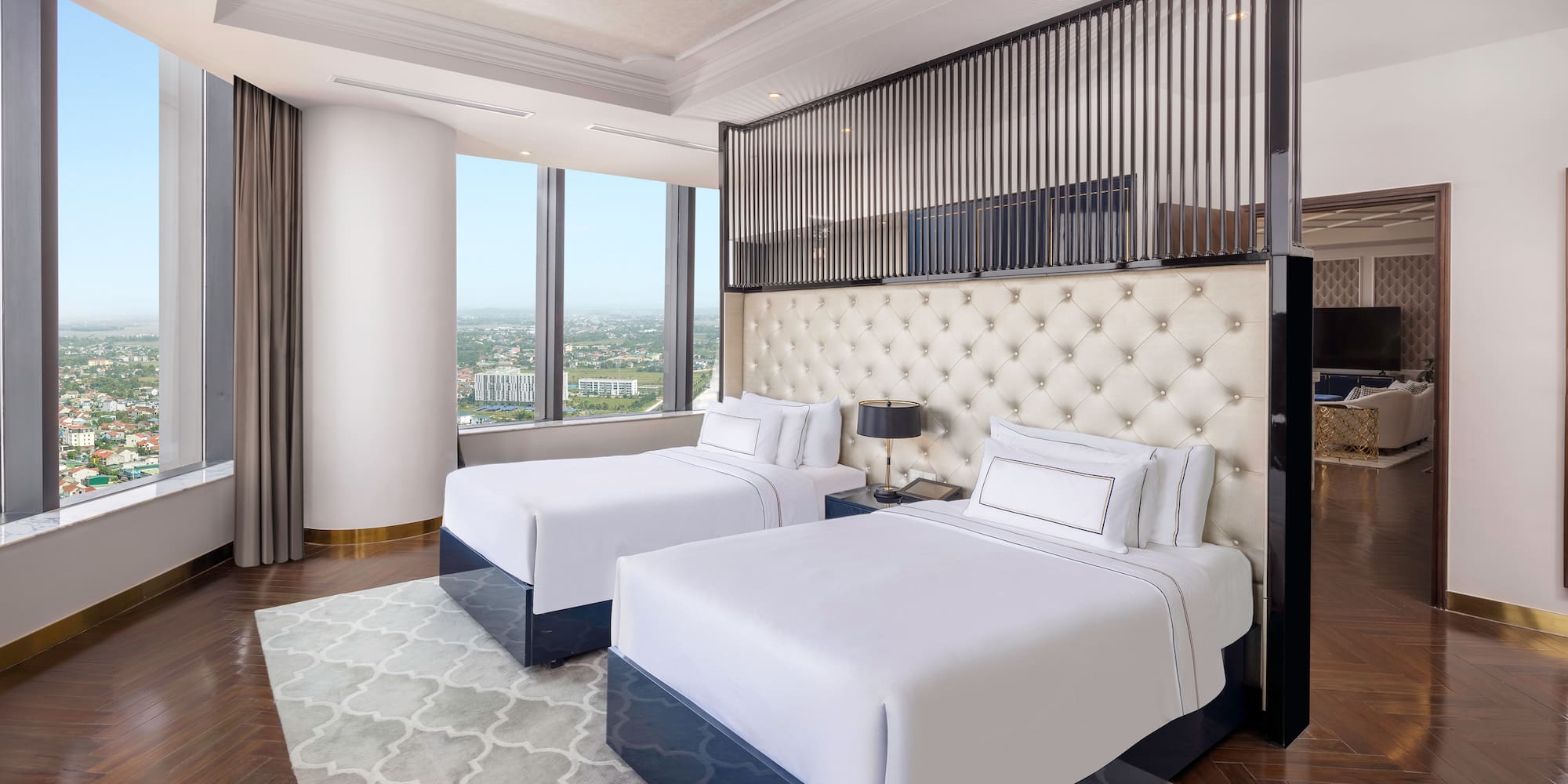 a room with two beds and a view of a city