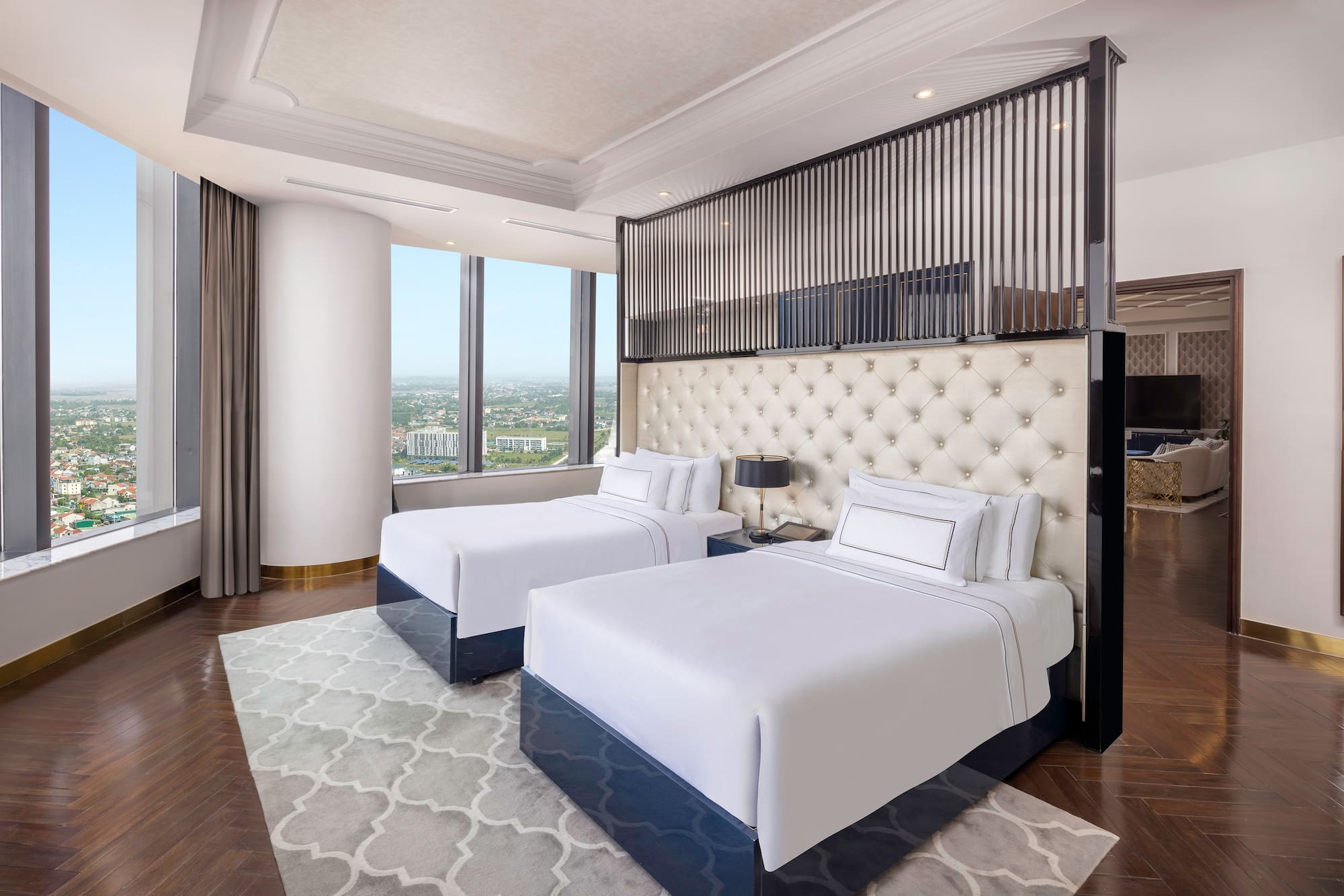 a room with two beds and a view of a city