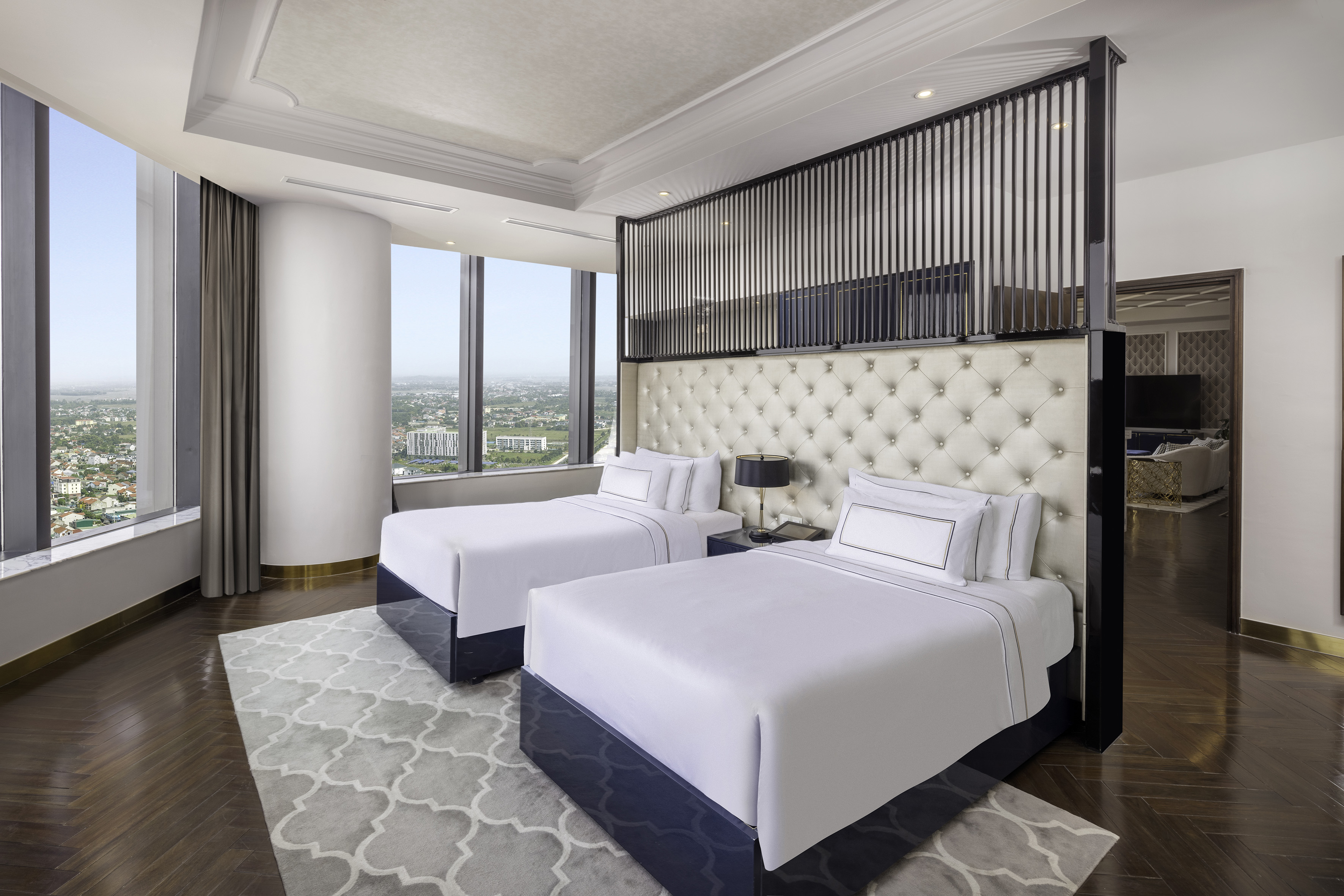 a room with two beds and a view of a city