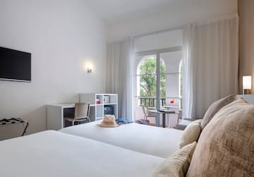 a room with two beds and a balcony