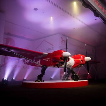 a red and white airplane on a stage