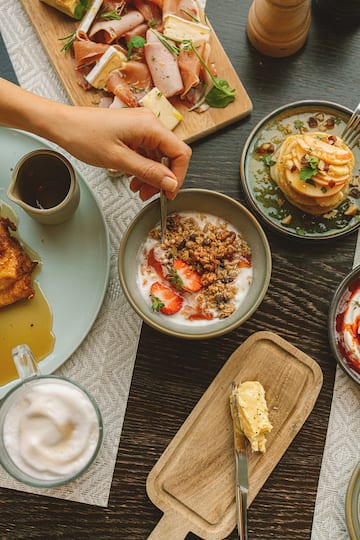 a person holding a spoon in a bowl of food