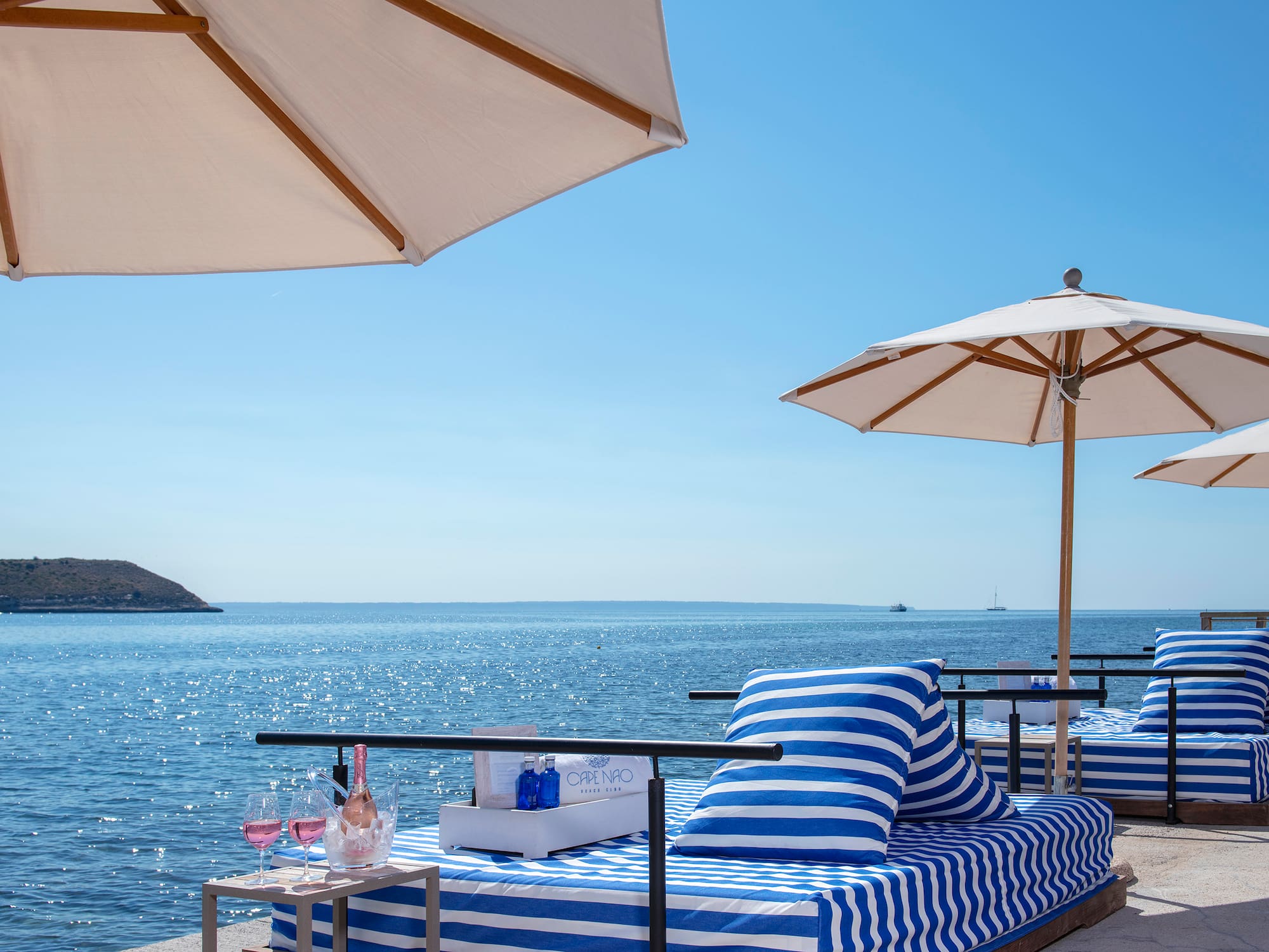 a beach with umbrellas and a bed