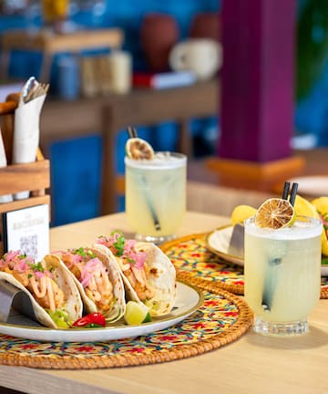 a plate of tacos and drinks on a table